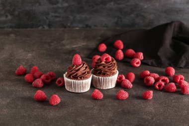 Siyah arka planda ahududu olan lezzetli çikolatalı kekler.