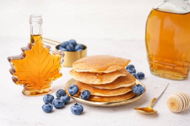 Beyaz arka planda yaban mersinli ve akçaağaç şuruplu lezzetli krepler.