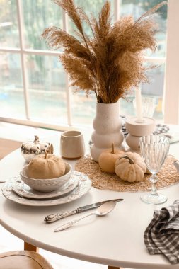 Balkabakları ve otlarla süslü zarif bir sonbahar sofrası.