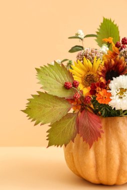 Turuncu arka planda balkabağı yapraklı güzel bir sonbahar buketi.