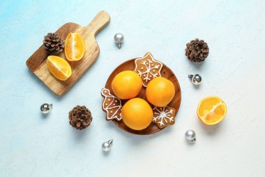 Lezzetli portakallı ahşap tabak ve açık mavi arka planda tatlı Noel kurabiyeleri.