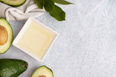 Taze avokadolar ve beyaz grunge arka planda esaslı yağlı kase.