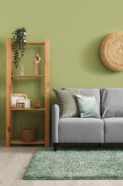 Gri kanepesi ve raf ünitesi olan şık bir oturma odası.