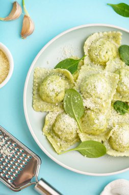 Mavi arka planda peynirli lezzetli ravioli tabağı, yakın plan.