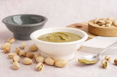 Fıstık ezmeli kase ve pembe grunge arka planda kaşık