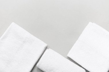 Gri zemin üzerinde temiz yumuşak havlular olan kompozisyon