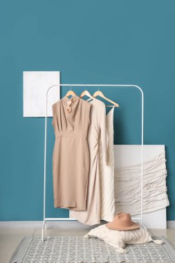 Şık kıyafetler ve mavi duvarın yanındaki boyalarla doldur.