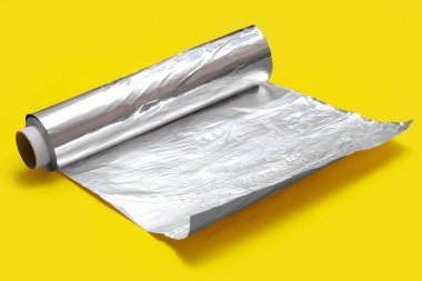 Aluminium foil roll on yellow background