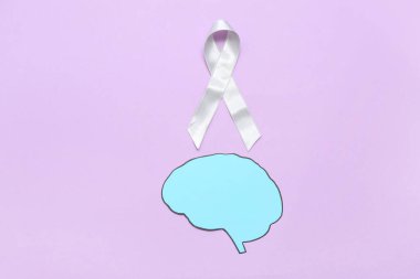 Mor arka planda gri farkındalık kurdelesi olan kağıt beyin. Kanser kavramı