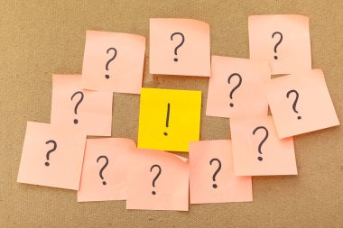 Üzerinde soru ve ünlem işaretleri olan yapışkan notlar.