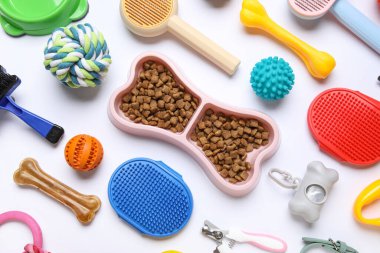 Kemik şeklinde yemek kasesi ve beyaz arka planda farklı hayvan aksesuarları.