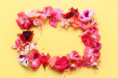 Sarı arka planda farklı güzel yenilebilir çiçeklerden yapılmış çerçeve