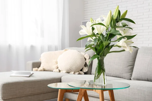 Gri kanepe ve sehpanın üzerinde nilüfer çiçekleri olan şık bir oturma odası. Yakın plan.