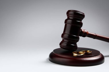 Işık arkaplanda alyansları olan yargıç tokmağı. Aile hukuku kavramı