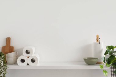 Mutfak duvarında kağıt havlu, bulaşık ve bitkilerle dolu raflar.