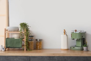 Mutfaktaki tezgahta kağıt havlu ve kahve makinesi var.