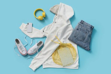 Mavi arka planda aksesuarları ve aletleri olan beyaz kapüşonlu.