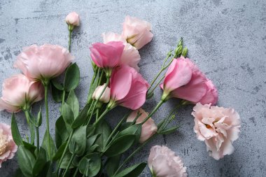 Gri grunge arka planda güzel Eustoma çiçeklerine sahip kompozisyon, yakın plan.