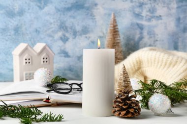 Noel dekoru ile yanan mum ve beyaz masa üzerinde kitap, yakın çekim