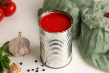 Beyaz arkaplanda domates ezmesi olan teneke kutu, yakın plan