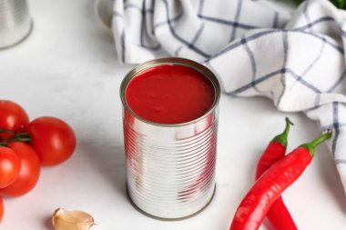 Teneke kutu domates ezmesi ve malzemeler beyaz arka planda, yakın plan.