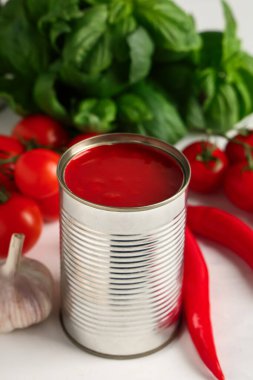 Teneke kutu domates ezmesi ve malzemeler beyaz arka planda, yakın plan.