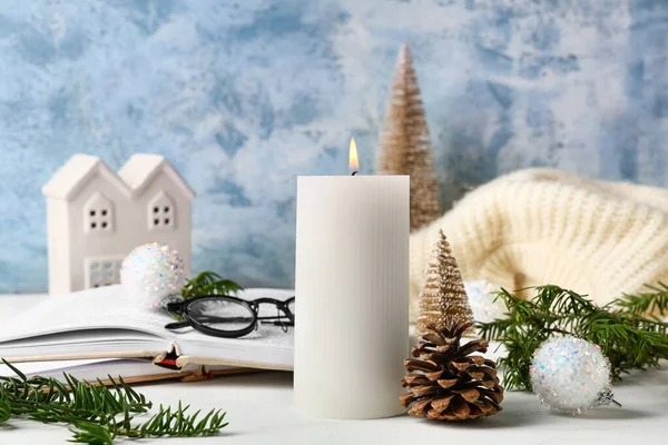 Noel dekoru ile yanan mum ve beyaz masa üzerinde kitap, yakın çekim