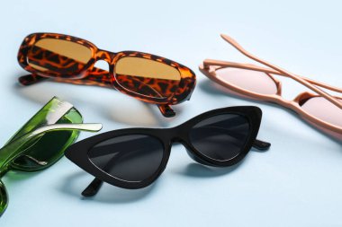 Mavi arka planda farklı modern gözlük, yakın plan.