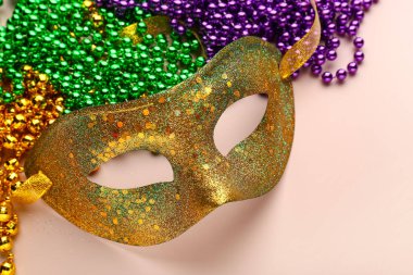 Bej arka planda Mardi Gras kutlaması için dekorlu parlak karnaval maskesi