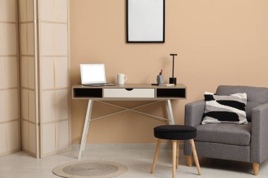 Çalışma odası, katlanan ekran, koltuk ve sehpası olan şık bir ofis.