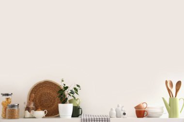 Mutfak gereçleri ve ışık duvarlı bir rafta.