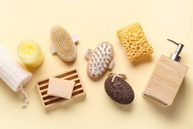 Bej arka planda masaj vücut fırçaları, sabun çubuğu, şişe ve kozmetik ürünler kavanozu ile kompozisyon, yakın plan