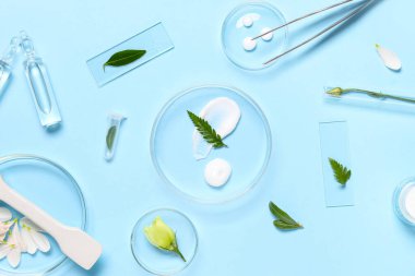 Mavi arka planda bitki örnekleri ve laboratuvar ekipmanları bulunan petri kapları