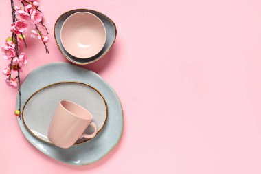 Pembe arka planda çiçek açan dalı olan güzel masa ayarları