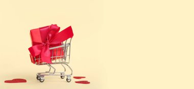 Bej arkaplanlı, mesaj için yeri olan mini bir alışveriş arabası. Sevgililer Günü kutlaması