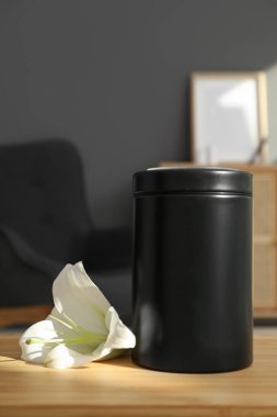 Morg vazosu ve beyaz zambak çiçeği odasındaki ahşap masada.