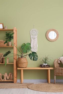 Yeşil duvarın yanındaki bankta ve raflarda.