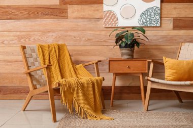 Oturma odasının iç tarafında çiçekli sandalyeler ve komodin.