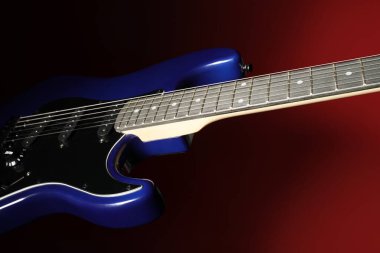 Kırmızı arkaplanda modern elektro gitar, yakın plan