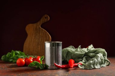 Fesleğen yapraklı konserve domates ezmesi ve koyu arkaplanda kırmızı biber.