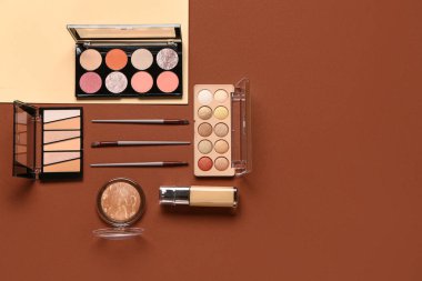 Güzel göz falı paletleri ve renkli arka planda farklı dekoratif kozmetikler.