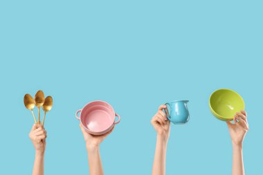 Kaseli kadın elleri, mavi arka planda sürahi ve kaşıklar