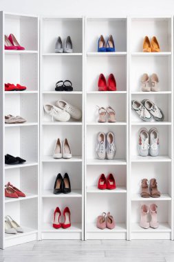 Odada farklı kadın ayakkabıları olan raf ünitesi.