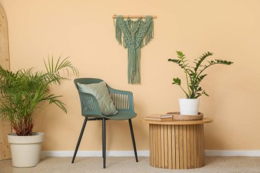 Kahve masası ve sandalye odanın içindeki bej duvarın yanında.