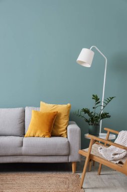 Gri kanepesi, koltuğu ve standart lambası olan şık bir oturma odası.