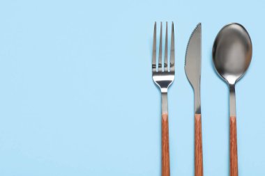 Mavi arka planda gümüş çatal bıçak takımı