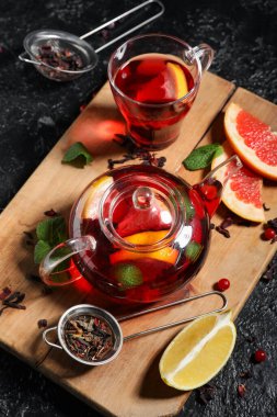 Sıcak meyve çaydanlığı ve siyah grunge arka plan malzemeleri, yakın plan.