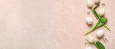 Paskalya yumurtaları ve pembe arka planda güzel çiçekler.