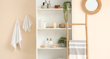 Raflar, merdiven ve havlularla dolu bir banyo.