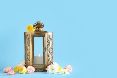 Mavi arka planda çiçekler olan Müslüman lambası. Ramazan kutlaması